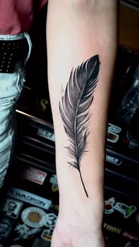 Tatuagem de pena em fine line feita por Egle Justino